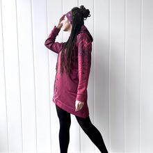 Ielādēt video galerijas pārlūkā, Women's A-line running skirt with an ombre (burgundy and pink) base and a Strelitzia floral pattern. The skirt has built-in black mid-length shorts with side pockets and a zipper pocket on the back.