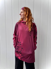 Ielādēt video galerijas pārlūkā, Women's A-line running skirt with an ombre (burgundy and pink) base and a Strelitzia floral pattern. The skirt has built-in black mid-length shorts with side pockets and a zipper pocket on the back.