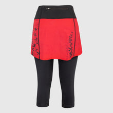 Load image into Gallery viewer, Women's A-line running skirt with an ombre (burgundy and pink) base and a Strelitzia floral pattern. The skirt has built-in black mid-length shorts with side pockets and a zipper pocket on the back.