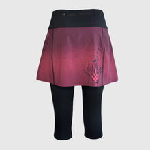 Ielādēt video galerijas pārlūkā, Women's A-line running skirt with an ombre (burgundy and pink) base and a Strelitzia floral pattern. The skirt has built-in black mid-length shorts with side pockets and a zipper pocket on the back.
