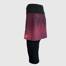 Ielādēt video galerijas pārlūkā, Women's A-line running skirt with an ombre (burgundy and pink) base and a Strelitzia floral pattern. The skirt has built-in black mid-length shorts with side pockets and a zipper pocket on the back.