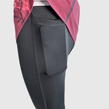 Ielādēt video galerijas pārlūkā, Women's A-line running skirt with an ombre (burgundy and pink) base and a Strelitzia floral pattern. The skirt has built-in black mid-length shorts with side pockets and a zipper pocket on the back.