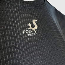 Load image into Gallery viewer, Close-up of a textured black garment with a logo and text on a light gray background